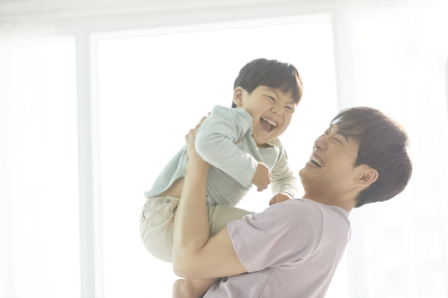 子どもを抱き上げるパパ